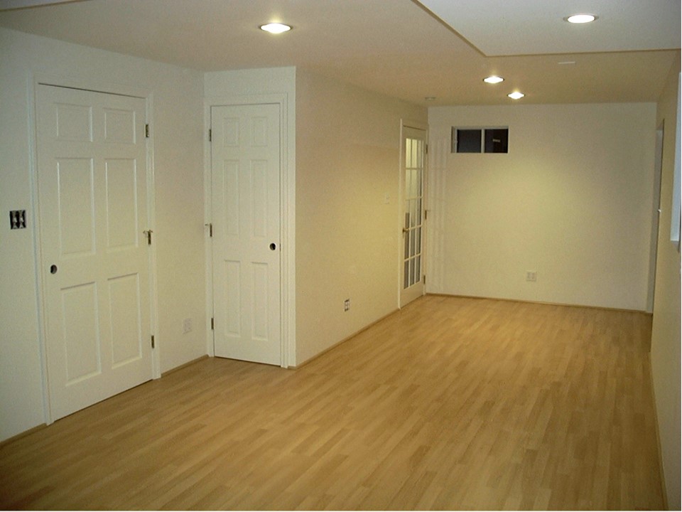 View of finished studio, looking towards closet doors and door leading to staircase